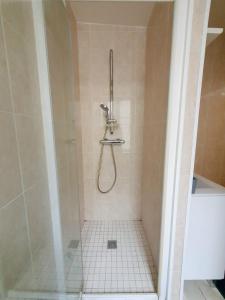 ein Bad mit einer Dusche und Fliesenboden in der Unterkunft Appartement Saint Martin in Ussel