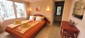 een slaapkamer met een bed met twee groene handdoeken erop bij Appartement Estaño in La Caleta +18 foto's