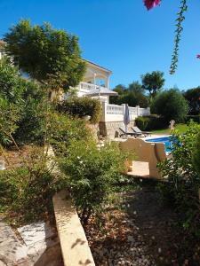 een tuin met een huis en een zwembad bij Appartement Estaño in La Caleta