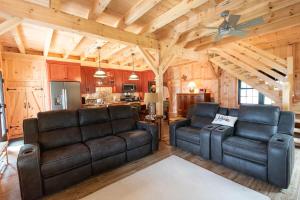 sala de estar con 2 sillas de cuero y cocina en Oceanview Barnhouse Retreat with Hot Tub, en Steuben