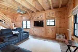 Una sala de estar con un sofá y un televisor. en Oceanview Barnhouse Retreat with Hot Tub, en Steuben