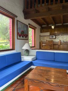 a living room with blue couches and a table at Tapalpa Country Club Hotel in Tapalpa