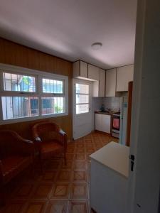 a kitchen with two chairs and a table and two windows at Casa a 2 cuadras del mar en Necochea in Necochea