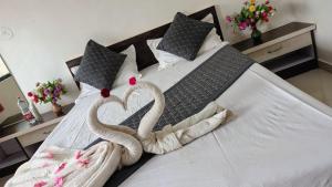 two swans made out of towels on a bed at Stay Classy Inn in Mahabaleshwar