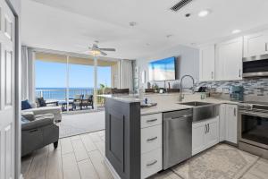 a kitchen with white cabinets and a view of the ocean at Beach Club unit 502C- Catalina in Gulf Highlands