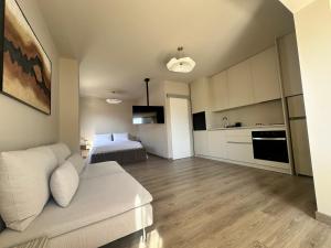 Una sala de estar con un sofá blanco y una cocina. en Coffee apartamento, Las Galletas, en Arona
