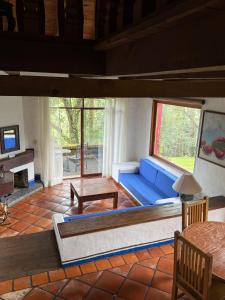 a living room with a blue couch and a table at Tapalpa Country Club Hotel in Tapalpa