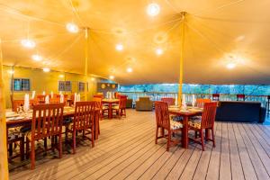 a dining room with tables and chairs in a tent at Mutsviri Game Lodge in Victoria Falls