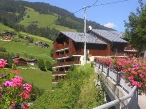 a building on a hill with flowers in front of it at Duplex cosy et spacieux avec piscine et balcon proche des pistes pour 4-5 personnes à Arêches-Beaufort - FR-1-342-171 in Arêches +5 photos