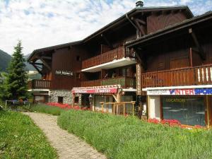 a large wooden building on top of a hill at Duplex spacieux 2 chambres avec piscine proche des pistes - FR-1-342-172 in Arêches