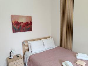 a bedroom with a bed and a painting on the wall at Ζ&Ζ Studios in Perea