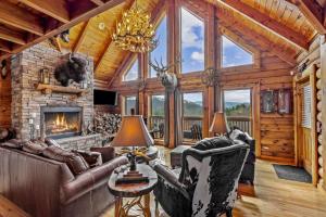 a living room with a stone fireplace and leather furniture at Ponderosa 1887 in Vilas