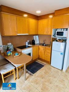 a kitchen with wooden cabinets and a white refrigerator at Safir in Son Bou