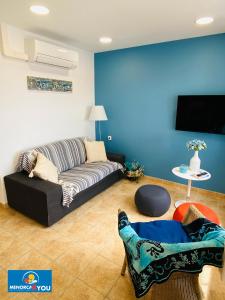 a living room with a couch and a blue wall at Safir in Son Bou
