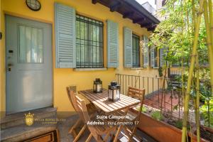 a porch with a table and chairs in front of a house at Milan Royal Suites - Centro in Milan