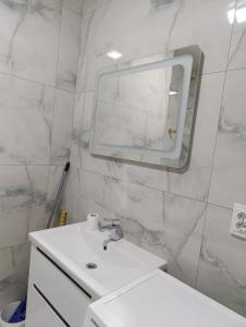 a white bathroom with a sink and a mirror at Стрийська Арена King Cross Автовокзал Новобуд in Lviv