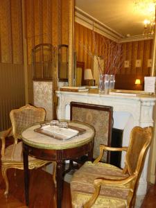 Una habitación con una mesa y sillas y una chimenea. en Hotel Windsor Home, en París