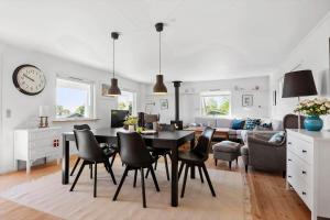 a dining room and living room with a table and chairs at 30459-Odder-Solskraenten-2 in Odder