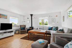 a living room with a couch and a tv at 30459-Odder-Solskraenten-2 in Odder