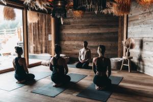 een groep mensen die in een yogales zitten bij Jufenalm BOHO & Wellnesshotel in Maria Alm am Steinernen Meer