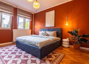 プリシュティナにあるSquare One APTのオレンジ色の壁のベッドルーム1室、ベッド1台が備わります。