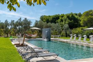 a pool with lounge chairs and a hammock at Villa Arabesque in Veglie