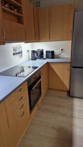 a kitchen with wooden cabinets and stainless steel appliances at Cosy apartment Central Kopavogur in Reykjavík