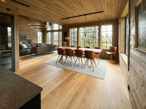 a dining room and living room with a table and chairs at Mountain Cabin With Views Over Jämtland's Expanse in Storhågna
