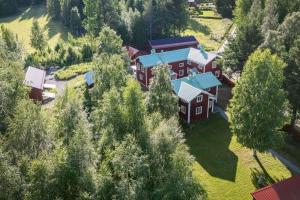 an aerial view of a large red house with trees at Annexet Orrabackens in Järvsö