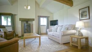 WhitewellにあるTunstall Ing Farmhouse - Duchy of Lancaster Estateのソファと暖炉のあるリビングルーム