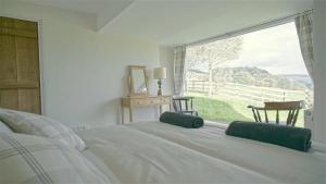 WhitewellにあるTunstall Ing Farmhouse - Duchy of Lancaster Estateのベッドと大きな窓のある寝室