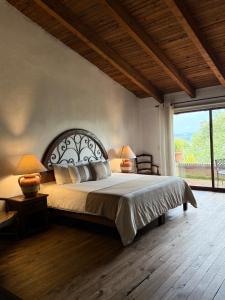 a bedroom with a large bed and a large window at Tapalpa Country Club Hotel in Tapalpa