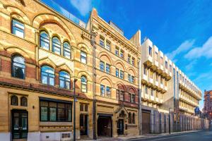 een groot bakstenen gebouw aan de kant van een straat bij Modern Leeds Central Stay -2 min walk from station in Leeds