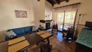 Una sala de estar con un sofá azul y una mesa. en Nuovo Margiolà Dolomiti, en Calalzo