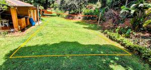 a yard with a net on the grass at Pousada dos Chalés - Araras in Araras Petropolis