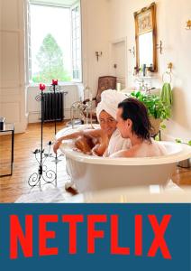 two women sitting in a bath tub in a bathroom at Séjour romantique ou professionnel au Château isigny, Charme et feu de cheminée in Isigny-le-Buat