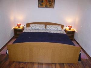 a bedroom with a large wooden bed with two night stands at Apartment Nono Anton in Kraljevica