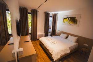 a small bedroom with a bed and two night stands at Calma Experience in Korçë +51 photos