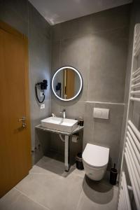 a bathroom with a sink and a toilet and a mirror at Calma Experience in Korçë