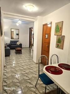 a living room with a couch and a table and chairs at Edificio ALONE com terraço na quadra da praia, espaçoso e silencioso in Rio de Janeiro