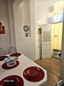 a room with a table with red plates and a toilet at Edificio ALONE com terraço na quadra da praia, espaçoso e silencioso in Rio de Janeiro