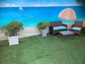 a patio with two chairs and a table and an umbrella at Maison confortable avec jardin à Marseille in Marseille +9 photos