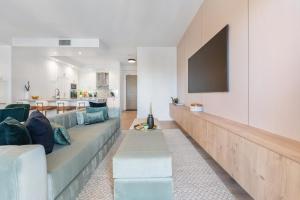 ein Wohnzimmer mit einem Sofa und einem Fernseher an der Wand in der Unterkunft Rosewood Skyline Penthouse - CN Tower Views, Downtown Toronto in Toronto