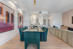 ein Esszimmer mit grünen Stühlen und einem Tisch in der Unterkunft Rosewood Skyline Penthouse - CN Tower Views, Downtown Toronto in Toronto