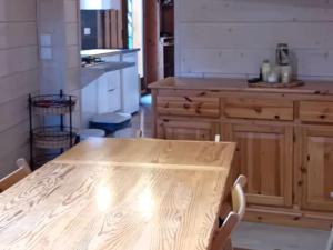 une cuisine avec une table en bois au milieu dans l'établissement Chalet rénové Les Gets 8 pers, central, 150m commerces, 350m pistes, terrasse sud, parking privé - FR-1-802-84, aux Gets 17 autres photos