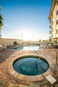 a small pool in a courtyard with chairs and a building at Vistas on the Gulf in St Pete Beach