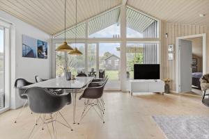 a dining room with a table and chairs and a tv at 30178-Odder-Chr-Christensensvej-9 in Beder
