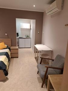 a room with a bed and a table and a kitchen at Résidence Rachel 12 in Mons