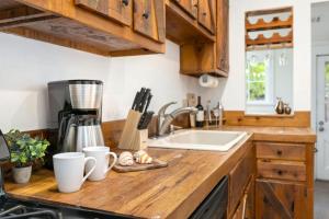 a kitchen counter with a sink and wooden cabinets at Oak Street Bungalow Walk to Old Town and CSU in Buckingham