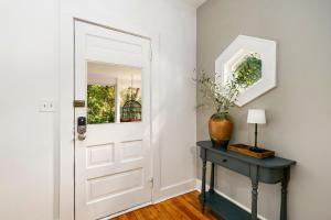 a white door in a room with a table and a vase at Oak Street Bungalow Walk to Old Town and CSU in Buckingham +26 photos